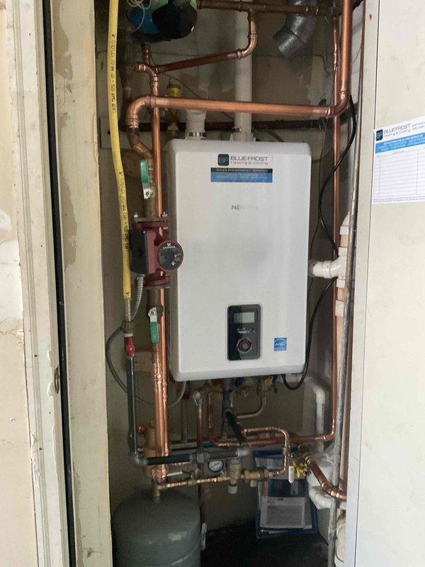 Completed installation of Navien combi boiler system with comprehensive copper piping network, including integration of reused circulator pump and existing PVC venting. The 20-hour installation featured professional plumbing connections with multiple isolation valves, pressure relief components, and dual expansion tanks for proper system pressurization and thermal expansion control. All connections were tested and verified operational with digital control panel programmed for optimal heating and domestic hot water performance.
