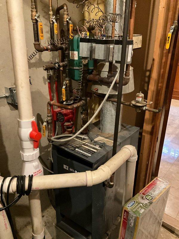 Completed non-member air conditioning tune-up and maintenance service on single AC system. Performed comprehensive inspection of indoor and outdoor equipment, verified thermostat operation and calibration showing heating mode set to 71 degrees, checked refrigerant levels and pressures, cleaned condenser coils, inspected electrical connections and capacitors, and tested system performance. Documented equipment age and specifications for customer records, photographed existing HVAC system configuration including furnace, water heater, and associated plumbing connections in mechanical room. Provided replacement estimate for aging AC equipment as requested, noting current system condition and recommended upgrade options for improved efficiency and reliability.