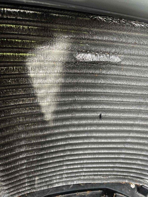 Completed comprehensive BFMA tune-up service on a 10+ year old air conditioning system during late morning hours. Performed standard maintenance protocol including inspection of condenser coils, which revealed moderate dust and debris accumulation with minor fin damage requiring attention. Evaporator coil assembly showed operational wear consistent with equipment age, with visible dirt buildup on aluminum fins and some alignment irregularities. Cleaned and serviced both coil assemblies to restore optimal heat transfer efficiency. Inspected all accessible system components, verified proper refrigerant levels, checked electrical connections, and tested system operation. Unit returned to normal operating parameters following tune-up procedures, with photographic documentation completed for service records.