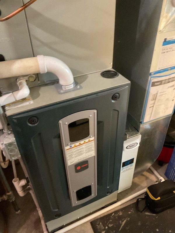 Completed comprehensive BFMA tune-up service on residential HVAC system including furnace and air conditioning unit, both over 2 years old. Performed full inspection of furnace cabinet with digital control panel, verified proper operation of all controls and safety indicators, and inspected PVC condensate drain lines and refrigerant lines for proper installation and condition. Inspected evaporator coil assembly, noting accumulation of dust and debris on vertical pleated fins; cleaned coil surfaces and replaced air filter to restore optimal airflow and system efficiency. All equipment tested and operating within normal parameters upon completion.