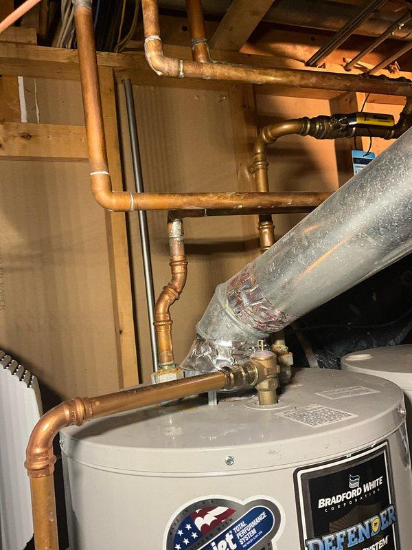 Completed comprehensive plumbing maintenance visit and inspection of residential water heating system. Documented dual InSinkErator instant hot water units and Bradford White water heater installation, including copper piping connections, pressure relief valves, shut-off valves, and associated plumbing infrastructure. All equipment photographed for maintenance records, with no immediate repairs required at time of visit.