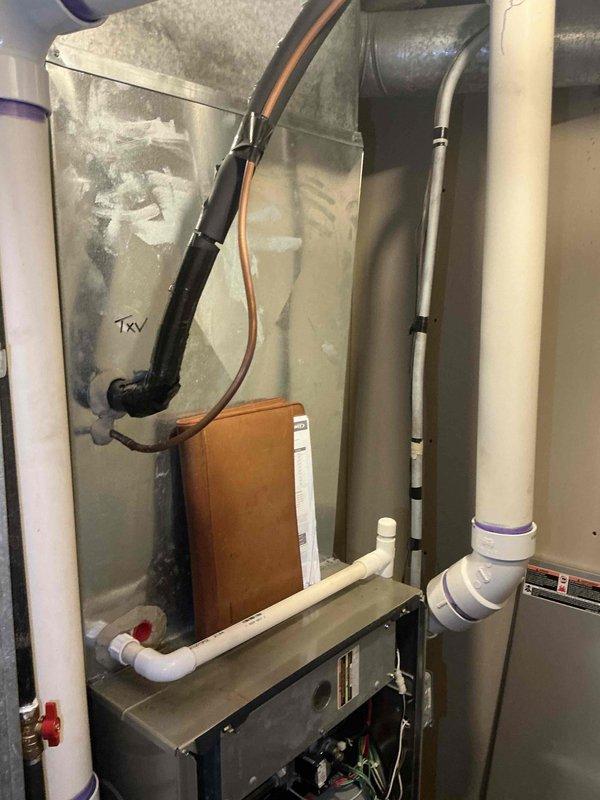 Performed comprehensive evaluation of existing residential HVAC system including furnace and air conditioning components located in basement utility area. System assessment revealed aging equipment with visible condensation on ductwork and TXV components, confirming previous diagnosis that unit requires either significant repairs or full replacement. Documented current system configuration including PVC condensate drainage, electrical panel with Square D breakers rated at various amperages (15-50 amp), and overall installation layout to provide accurate replacement estimate for complete system upgrade.