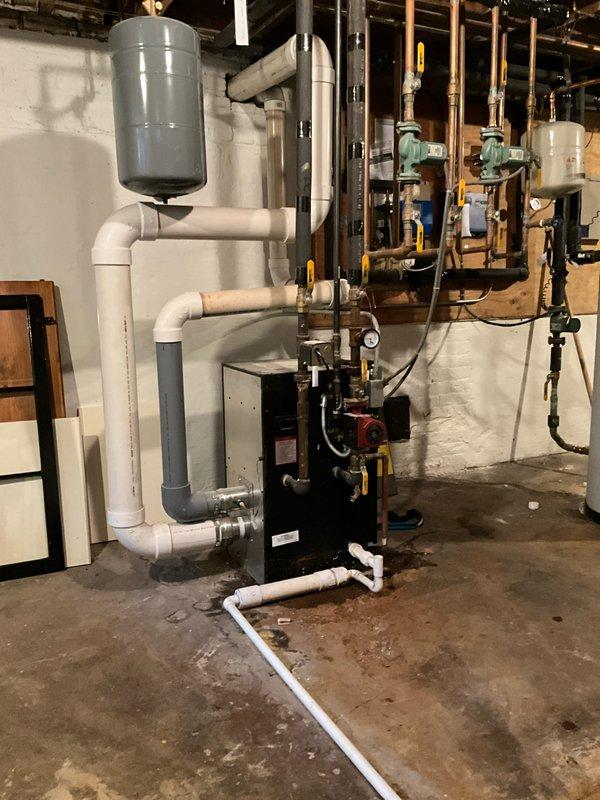 Responded to after hours service call for boiler system evaluation. Upon arrival, conducted comprehensive inspection of hydronic heating system including black boiler unit, gray expansion tank, white PVC piping network, green circulation pumps, copper gas lines, and associated mechanical components in basement mechanical room. Documented existing equipment configuration and current operational status through photographic assessment of complete installation including all piping manifolds, valves, controls, and safety devices. System shows standard residential hydronic heating setup with properly mounted expansion tank, circulation pumps, and water heater integration.