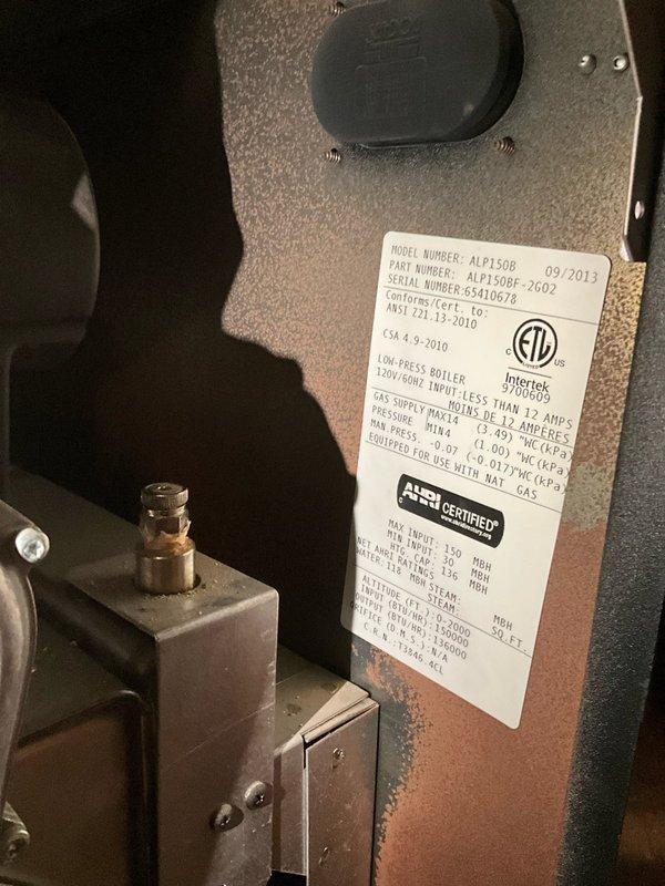 Responded to after hours call for heating system issue. Upon arrival, inspected ASCO-specified boiler unit model ALP150B (serial number 8410678, manufactured 09/2012) with 120V/60Hz electrical specifications. Removed front access panel to assess internal components and heat exchanger condition. Documented equipment specifications from manufacturer label including BTU ratings, gas pressure parameters, and steam capacity information. Verified all electrical connections, including red and black wiring to control panel and digital display unit. Inspected circulation pump operation and associated copper piping with brass fittings for proper function. Checked all plumbing connections and valve assemblies for leaks or operational concerns. Photographed equipment nameplate data and internal components for service records. System evaluated and operational status confirmed before departing site.
