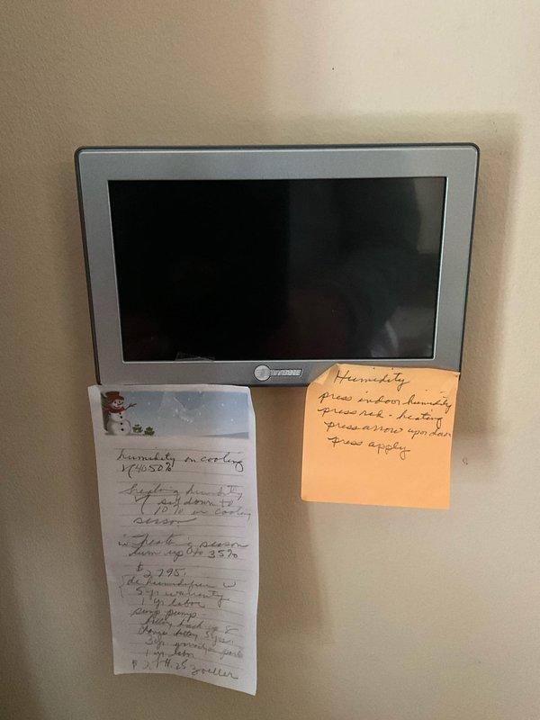 Responded to after-hours emergency call for water leaking from AC unit with malfunctioning condensate pump and non-responsive thermostat. Upon arrival, inspected wall-mounted digital thermostat displaying blank screen and confirmed complete loss of power to control unit, preventing system shutdown. Proceeded to basement mechanical room and evaluated HVAC system including furnace, multi-zone manifold assembly with green valve controls, and floor-mounted condensate pump with pressure gauge. Identified condensate pump failure as primary cause of water leakage and thermostat malfunction related to electrical issue. Documented equipment conditions including copper and PEX piping connections, red manifold distribution system, expansion tank, and associated electrical conduits for further diagnostic evaluation and repair recommendations.