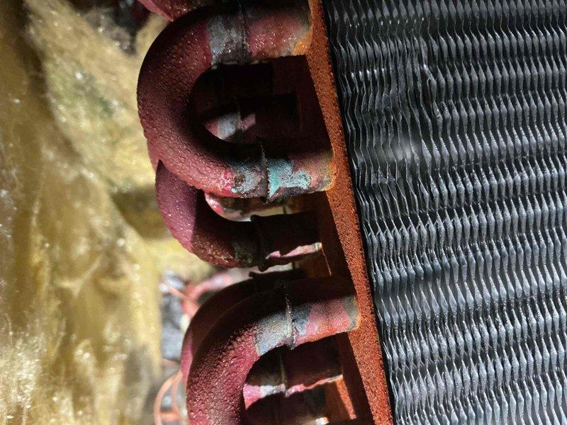 Completed comprehensive BFMA tune-up service on 8-year-old air conditioning system during scheduled afternoon appointment. Performed full system diagnostics including electrical measurements with clamp meter showing 185-amp reading, inspected outdoor condenser unit and indoor evaporator coil assembly. Noted aged foam insulation on refrigerant lines showing deterioration and copper piping displaying oxidation with blue-green patina, along with dust accumulation on evaporator coil fins; system operational and all measurements within acceptable parameters for continued service.