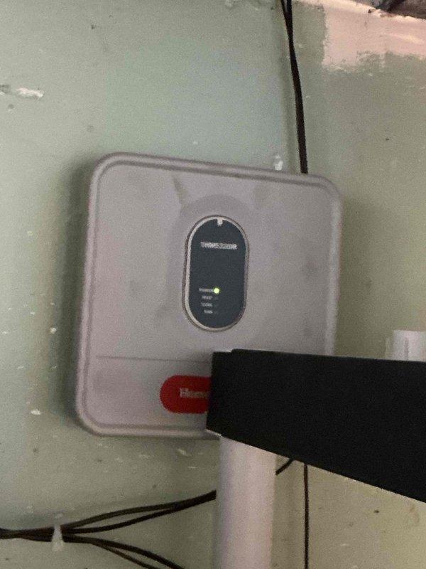 Conducted sales estimate for high-efficiency air conditioning system upgrade. Customer's existing AC unit is currently operational but requesting evaluation for high-efficiency replacement options. Documented existing HVAC control system including Resideo thermostat/control unit with smart home integration capabilities and associated mechanical components in utility area for proper equipment sizing and compatibility assessment.