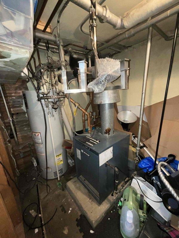Responded to service call for non-operational boiler system in residential mechanical room. Conducted comprehensive assessment of existing heating equipment, including navy-colored boiler unit, associated ductwork, copper and PVC piping connections, and interconnected HVAC components. Documented current system configuration with detailed photographs showing boiler installation, flexible silver insulated ductwork, gas lines, water supply connections, and mechanical equipment layout for estimate preparation purposes.