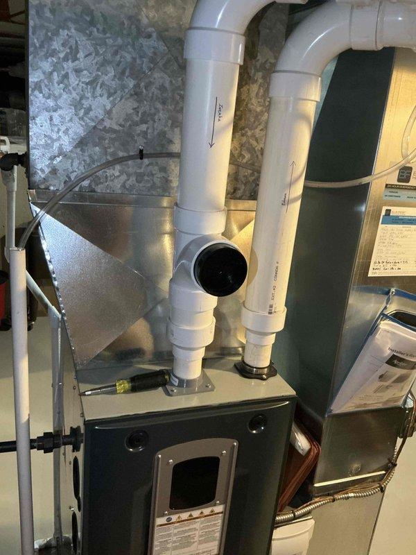 Conducted on-site evaluation of existing HVAC system to provide replacement estimate for aging air conditioning condenser unit and evaporator coil. Current system operational but nearing end of service life, prompting proactive replacement consideration. Documented existing indoor furnace and air handler configuration with PVC venting system, metallic plenum connections, and ductwork arrangement in basement installation. Assessed outdoor condenser unit positioned on concrete pad against exterior wall with proper clearances and electrical disconnect. Photographed equipment specifications and installation conditions to prepare comprehensive replacement proposal. Customer eligible for membership discount credits applicable toward new air conditioning and furnace equipment.