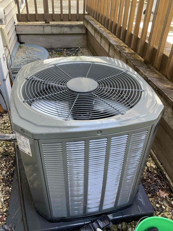 Completed comprehensive BFMA tune-up service on residential air conditioning system with 5-year-old outdoor condenser unit. Performed full system inspection, measured electrical amperage at 205.1 amps to verify compressor operation within manufacturer specifications, and documented equipment condition with unit positioned in recessed alcove area. All components operating properly with no deficiencies noted during maintenance visit.