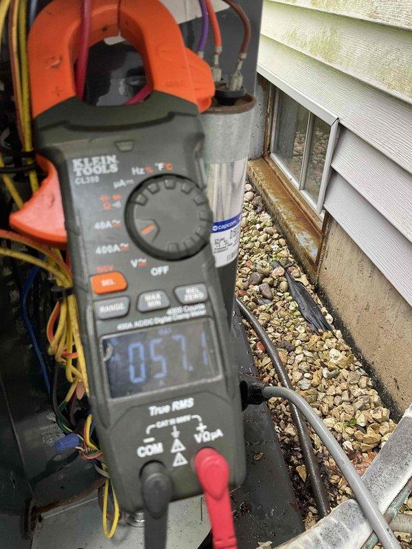 Completed comprehensive BFMA tune-up service on residential air conditioning system with 5-year-old outdoor condenser unit. Performed full system inspection, measured electrical amperage at 205.1 amps to verify compressor operation within manufacturer specifications, and documented equipment condition with unit positioned in recessed alcove area. All components operating properly with no deficiencies noted during maintenance visit.