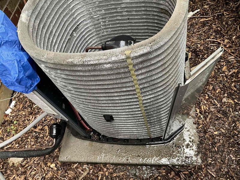 Completed comprehensive BFMA tune-up service on 7-year-old residential air conditioning system. Removed top panel and inspected condenser unit, noting accumulation of dirt and debris on condenser coils. Performed thorough cleaning of cylindrical condenser coil fins to restore proper airflow and heat transfer efficiency. Inspected compressor motor, copper refrigerant lines, and electrical connections, confirming all components operational. Verified unit mounted securely on concrete pad with proper clearances maintained. Reassembled unit and restored to normal operation.