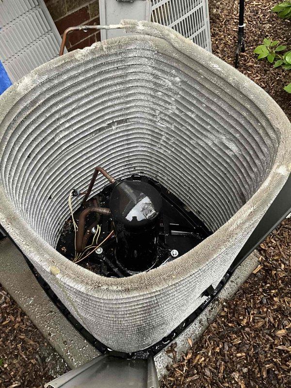 Completed comprehensive BFMA tune-up service on 7-year-old residential air conditioning system. Removed top panel and inspected condenser unit, noting accumulation of dirt and debris on condenser coils. Performed thorough cleaning of cylindrical condenser coil fins to restore proper airflow and heat transfer efficiency. Inspected compressor motor, copper refrigerant lines, and electrical connections, confirming all components operational. Verified unit mounted securely on concrete pad with proper clearances maintained. Reassembled unit and restored to normal operation.