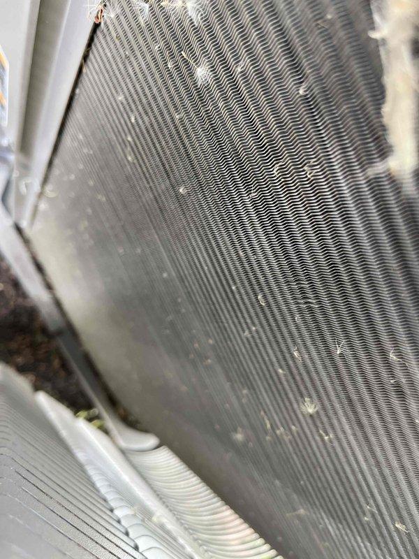 Completed comprehensive BFMA tune-up service on Trane 4TTX4060A1000CA outdoor condensing unit. Inspected condenser coil and fins, noting moderate accumulation of dirt, dust, and environmental debris between fin spacing that required attention. Performed standard preventive maintenance procedures including system evaluation, component inspection, and documentation of unit condition with electrical specifications verified at 208-230V operation.