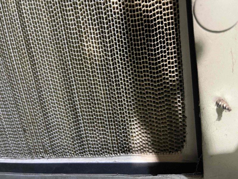 Completed comprehensive BFMA tune-up service on a one-year-old air conditioning system, including full inspection of evaporator coils and air filtration components. Documented system condition through photographs showing hexagonal mesh filter grille and aluminum fin coil assembly with minor dust accumulation between fins. All components inspected and system operating within normal parameters for scheduled preventive maintenance under recurring service agreement.