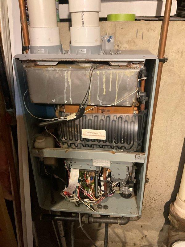 Completed comprehensive tune-up service on wall-mounted tankless water heater unit. Performed thorough inspection of all internal components including heat exchanger, burner assembly, and control board. Cleaned heat exchanger surfaces, verified proper venting through white PVC exhaust pipes, and inspected all copper plumbing connections for leaks or corrosion. Tested unit operation, confirmed proper gas combustion, and verified all electrical connections and safety controls were functioning correctly. Unit returned to normal operating condition with all components performing within manufacturer specifications.