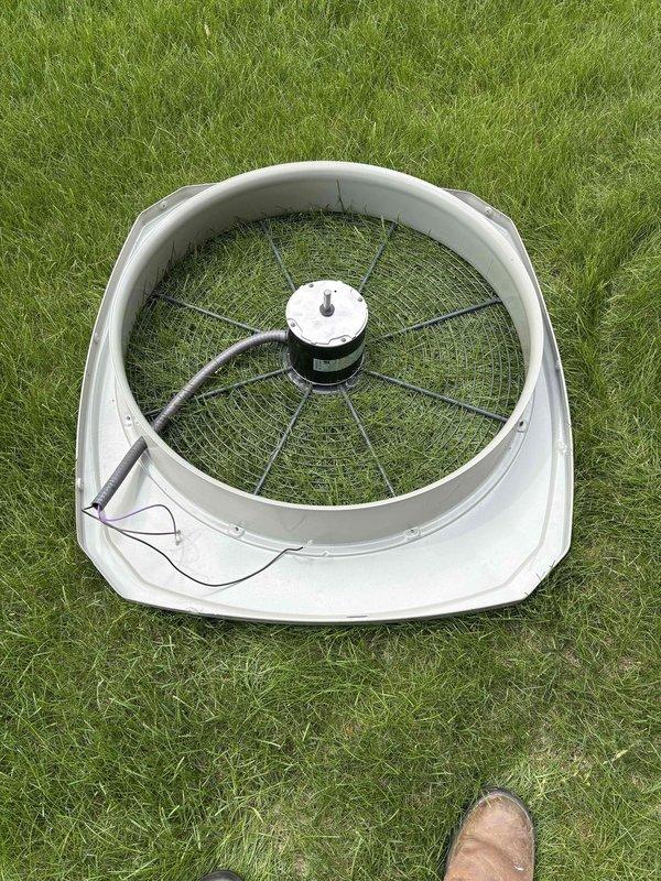 Replaced failed outdoor condenser fan motor due to severe corrosion and deterioration. Removed old motor assembly from unit, installed new motor with protective fan guard and housing, and verified proper operation. Unit restored to full cooling capacity.