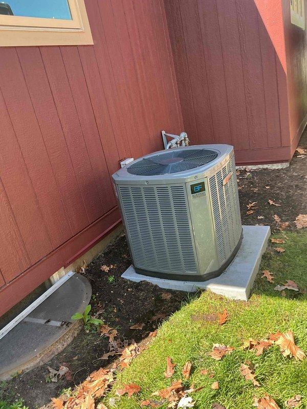 Completed comprehensive BFMA preventive maintenance tune-up on 4-year-old residential air conditioning system. Performed full system inspection of outdoor condenser unit, cleared accumulated leaf debris from around equipment and concrete pad, verified proper airflow through cooling fins, checked electrical connections and disconnect, tested system operation, and documented equipment condition with photographic records. Unit operating within normal parameters upon service completion.