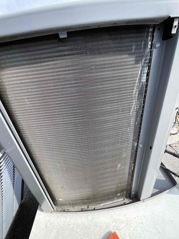 Completed comprehensive BFMA tune-up on rooftop-mounted air conditioning unit aged 4+ years. Performed full system inspection with access panel removal to evaluate condenser coil condition, noting dust and debris accumulation on horizontal fins typical of outdoor installation. Conducted standard maintenance protocol including visual assessment of internal components, coil examination, and overall equipment operational review to ensure proper system performance for the cooling season.