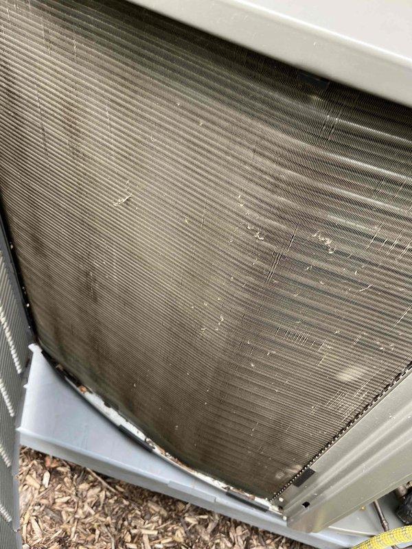 Completed comprehensive air conditioning tune-up service on residential HVAC system. Performed thorough inspection of outdoor condensing unit, noting accumulated debris and environmental buildup on condenser coil fins requiring attention. Inspected indoor air filter assembly, which appeared clean and in good operational condition with proper pleating and structural integrity intact. System operational and ready for cooling season.