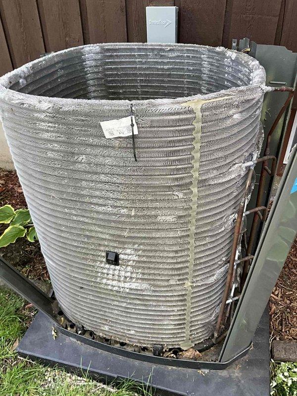 Performed comprehensive BFMA tune-up on residential air conditioning system over 2 years old. Serviced outdoor condenser unit which exhibited significant accumulation of dust, dirt, and debris on cooling fins and substantial leaf buildup around compressor component within housing. Cleaned condenser coils, removed organic debris from unit interior, inspected refrigerant lines and electrical connections, replaced air filters, and verified system operation to restore optimal cooling efficiency.
