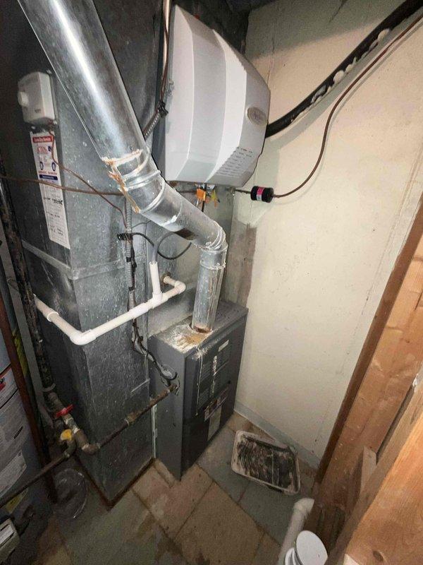 Conducted comprehensive sales estimate for full HVAC system replacement in residential basement mechanical room. Evaluated existing furnace, air handler, ductwork configuration, and auxiliary equipment including humidifier and condensate pump system. Assessed current equipment condition, installation quality, and proper connections of all mechanical components. Documented existing gray furnace unit with metallic ductwork, wall-mounted humidifier with associated copper and PVC piping, and condensate management system. Photographed complete HVAC setup to prepare customized equipment replacement proposal matching home's specific comfort requirements and system specifications.