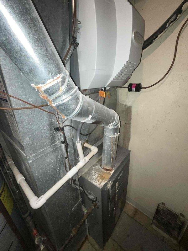 Conducted comprehensive sales estimate for full HVAC system replacement in residential basement mechanical room. Evaluated existing furnace, air handler, ductwork configuration, and auxiliary equipment including humidifier and condensate pump system. Assessed current equipment condition, installation quality, and proper connections of all mechanical components. Documented existing gray furnace unit with metallic ductwork, wall-mounted humidifier with associated copper and PVC piping, and condensate management system. Photographed complete HVAC setup to prepare customized equipment replacement proposal matching home's specific comfort requirements and system specifications.