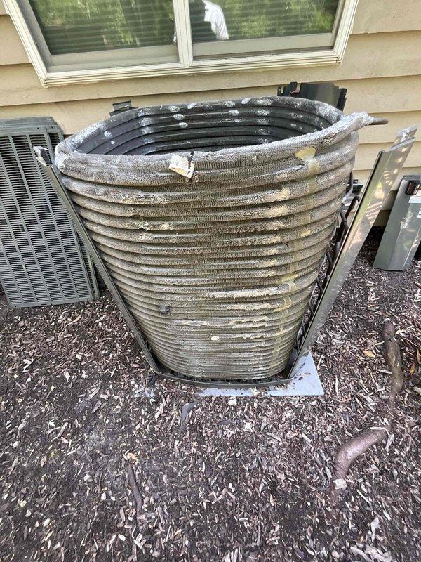 Completed comprehensive BFMA tune-up on 8+ year old outdoor AC unit, including inspection and cleaning of condenser coil assembly which showed moderate dirt accumulation and weathering on metal fins. Verified all electrical connections, tested system operation, and confirmed proper function of associated water heater and plumbing connections in basement utility area.