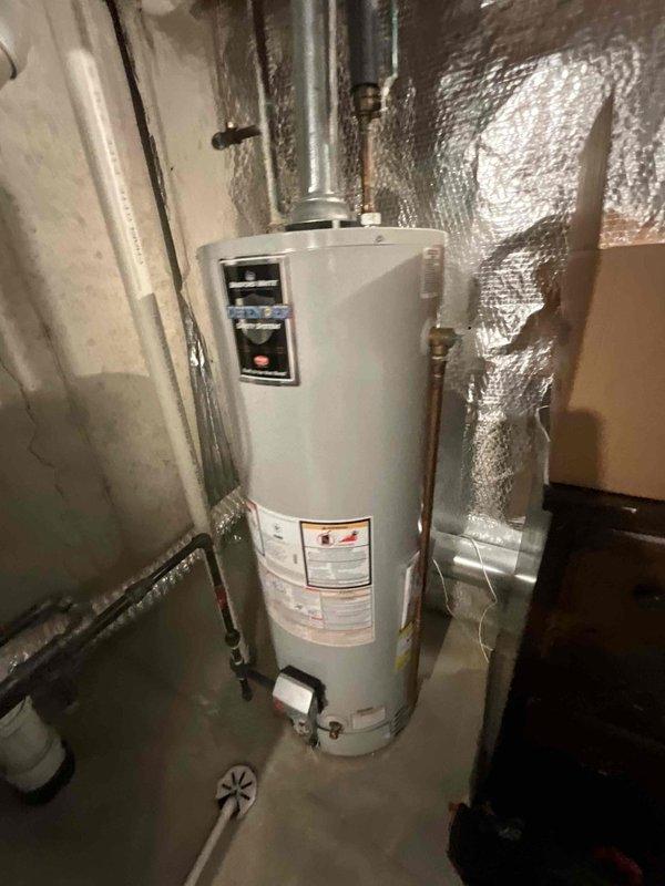 Completed comprehensive BFMA tune-up on 8+ year old outdoor AC unit, including inspection and cleaning of condenser coil assembly which showed moderate dirt accumulation and weathering on metal fins. Verified all electrical connections, tested system operation, and confirmed proper function of associated water heater and plumbing connections in basement utility area.