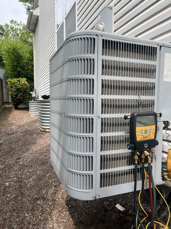 Responded to after-hours service call for air conditioning system not cooling at residential property. Upon arrival, performed diagnostic evaluation of 13-year-old R410A system using Fieldpiece SMAN refrigerant manifold and micron gauge. Connected diagnostic equipment to outdoor condensing unit and measured system pressures, superheat at 33.1°F, and subcooling at 8.1°F. Saturation temperatures recorded at 38.7°F and 94.7°F with operating pressures of 1160 psig low side and 2962 psig high side, indicating potential refrigerant charge issues or system performance degradation consistent with aging equipment.