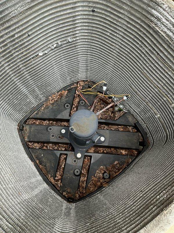 Completed comprehensive BFMA tune-up service on 6-year-old air conditioning system. Performed standard maintenance protocol including system inspection, thermostat verification showing unit cooling to 75°F setpoint, and condenser unit service. Removed accumulated organic debris including leaves and plant material from condenser fan assembly and interior housing, cleaned fan blades and motor area, and verified proper airflow through unit.