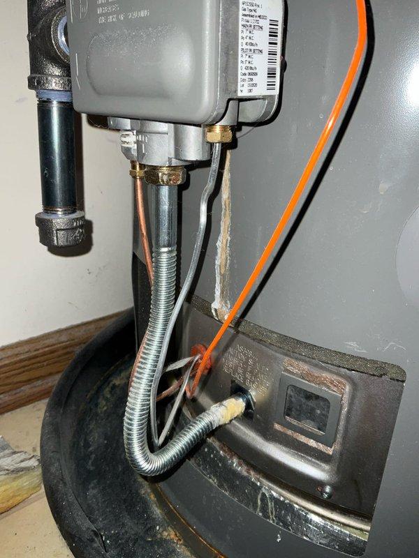 Responded to no hot water complaint at residential property. Upon arrival, inspected Rheem Professional Blue Frost tanked water heater and associated components. Evaluated gas control valve assembly, including brass fittings, pipe connections, and electrical conduit. Examined water heater plumbing connections at top of unit, including copper supply lines with brass fittings and red-handled ball valve on cold water inlet. Verified proper installation of galvanized vent pipe and all safety components. Diagnosed issue with gas control valve preventing proper heating function. Restored hot water service to residence. Unit tested and operating normally at time of departure.