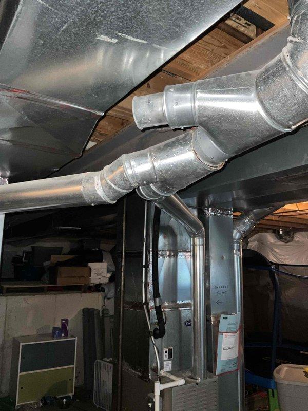 Responded to no cooling complaint on residential HVAC system that had been inoperative since previous summer. Upon inspection, discovered significant separation and cracking at ductwork joint connection on main supply plenum, causing substantial air leakage and loss of conditioned air delivery. Documented condition of 21+ year old system with photos showing compromised ductwork integrity and overall equipment age. Provided assessment of failed components and presented replacement options for aging unit that has exceeded typical service life expectancy.