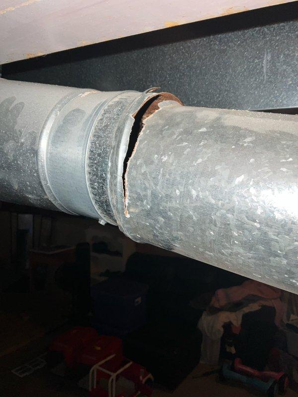 Responded to no cooling complaint on residential HVAC system that had been inoperative since previous summer. Upon inspection, discovered significant separation and cracking at ductwork joint connection on main supply plenum, causing substantial air leakage and loss of conditioned air delivery. Documented condition of 21+ year old system with photos showing compromised ductwork integrity and overall equipment age. Provided assessment of failed components and presented replacement options for aging unit that has exceeded typical service life expectancy.
