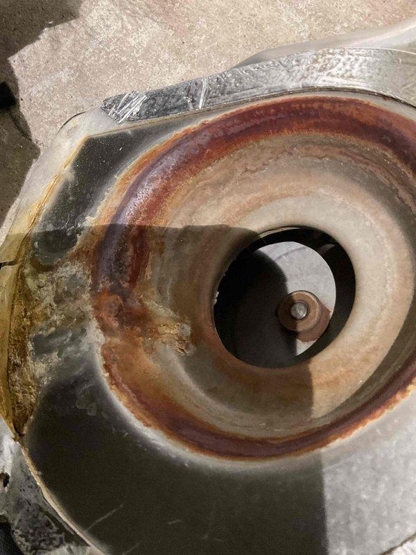 # HVAC Service Report - No Heat Call

Responded to residential no heat call. Upon arrival, conducted system inspection and identified severe rust and corrosion on the blower assembly and heat exchanger components. The extensive oxidation and deterioration observed on the interior metal surfaces indicated prolonged exposure to moisture and compromised system integrity. The circular motor housing and blower assembly showed reddish-brown rust stains forming concentric patterns, with additional greenish-gray discoloration suggesting advanced corrosion. Evidence of moisture accumulation was visible within the central opening of the assembly, contributing to the accelerated deterioration of metal components.

The condition of the affected components posed both operational failure and potential safety concerns. The rust formation and surface degradation throughout the blower assembly would significantly impair airflow and heat distribution efficiency. Documented the extent of damage through p