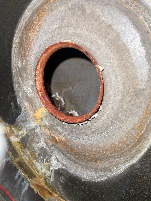 # HVAC Service Report - No Heat Call

Responded to residential no heat call. Upon arrival, conducted system inspection and identified severe rust and corrosion on the blower assembly and heat exchanger components. The extensive oxidation and deterioration observed on the interior metal surfaces indicated prolonged exposure to moisture and compromised system integrity. The circular motor housing and blower assembly showed reddish-brown rust stains forming concentric patterns, with additional greenish-gray discoloration suggesting advanced corrosion. Evidence of moisture accumulation was visible within the central opening of the assembly, contributing to the accelerated deterioration of metal components.

The condition of the affected components posed both operational failure and potential safety concerns. The rust formation and surface degradation throughout the blower assembly would significantly impair airflow and heat distribution efficiency. Documented the extent of damage through p