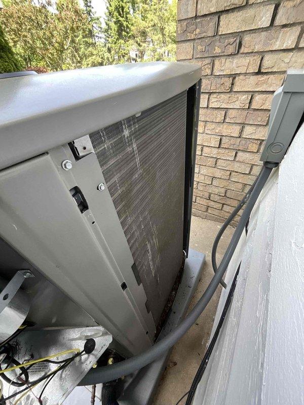 Completed comprehensive BFMA tune-up service on residential split-system air conditioning unit. Performed thorough inspection of outdoor condensing unit, including examination of condenser coil which showed dust and dirt accumulation between fins. Conducted standard AC maintenance procedures, replaced air filter as part of semi-annual filter change program, and verified all system components were operating within normal parameters. Unit access panels were opened to inspect internal components including finned heat exchanger coil, electrical connections, and mounting hardware. All work completed on 1-year-old equipment, with unit secured and returned to proper operating condition upon service completion.