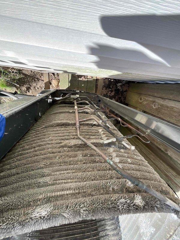 Completed comprehensive BFMA tune-up service on an 8+ year old outdoor air conditioning unit during afternoon appointment window. Performed thorough inspection of evaporator coils, which revealed heavy accumulation of dust, dirt, and debris significantly compromising system efficiency. Inspected electrical components including capacitor, contactor, and associated wiring connections; verified all connections were secure and functioning properly. Examined refrigerant lines for signs of wear or damage. Documented unit condition with detailed photographs showing internal components, coil condition, and electrical compartment. Recommended professional coil cleaning to restore optimal heat transfer efficiency and system performance.