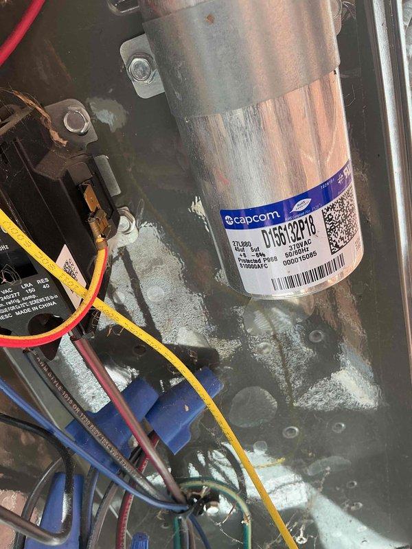 Completed comprehensive BFMA tune-up on residential air conditioning system over 4 years old. Performed electrical diagnostics using multimeter to verify proper voltage and amperage readings at outdoor unit. Inspected capacitor showing model 01SC139RC0 rated at 21ufd 370V, noting white residue buildup on equipment surface and mounting platform indicating possible condensation or corrosion concerns that were addressed during service.