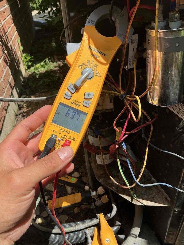 Responded to callback for A/C unit shutting off intermittently during operation. Upon arrival, accessed outdoor condensing unit electrical panel and performed diagnostic testing. Measured compressor amperage at 63.17 amps using clamp meter to verify electrical performance. Inspected control board connections, capacitor, and all wire terminations within the electrical compartment. Found and addressed wiring concerns related to previous service visit. Verified proper wire connections at contactor and capacitor terminals, securing all connections with appropriate wire nuts. Cleaned debris from electrical panel base. System tested and operating normally at time of departure.