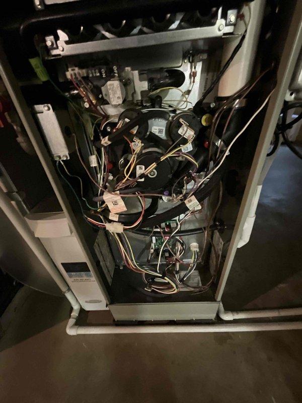 Completed comprehensive BFMA tune-up service on 4-year-old HVAC system, including full AC inspection and maintenance. Performed standard preventive maintenance procedures on furnace unit, inspecting all electrical connections, control boards, blower motor assembly, and safety components to ensure proper operation. Documented equipment condition with photos showing interior electrical components and auxiliary systems including sump pump in basement utility area.
