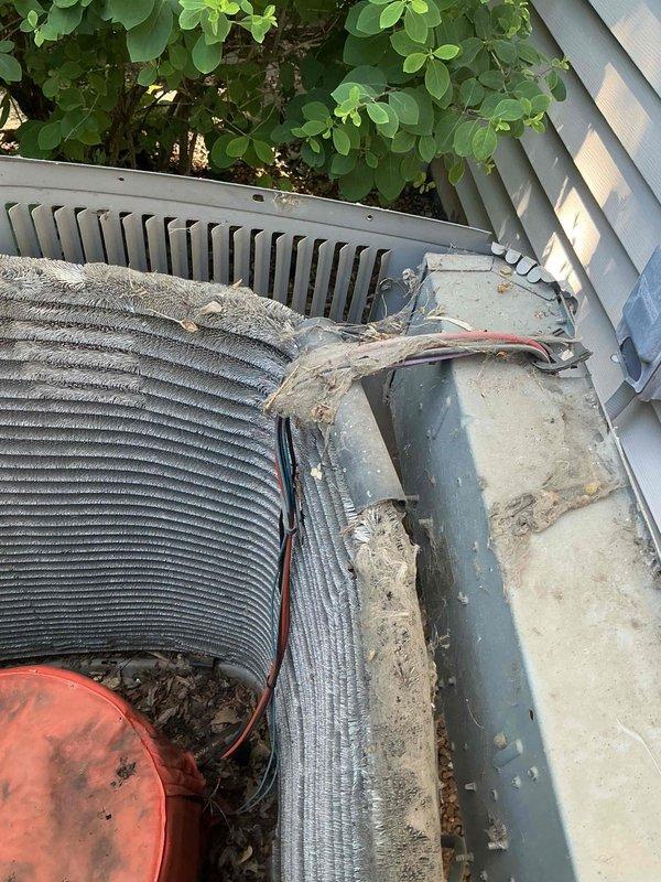 Completed comprehensive AC tune-up on 24+ year old outdoor condensing unit. Removed accumulated organic debris, dirt, and plant material from cooling fins and top surface. Performed electrical diagnostics including capacitor testing with digital multimeter to verify proper system operation and component functionality.