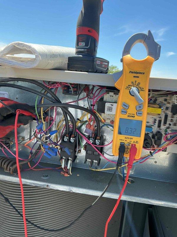 Responded to commercial no cooling call on rooftop unit. Upon arrival, verified unit was not operating. Performed electrical diagnostics using clamp meter to check amperage draws and voltage at contactor assembly. Measured 93.2A and 102.3A readings during testing sequence. Inspected control panel wiring, contactors, and associated electrical components. Condenser coil found in clean condition with no airflow restrictions. Identified issue with electrical control circuit preventing unit startup. Restored unit to normal operation and verified proper amperage and cooling cycle.