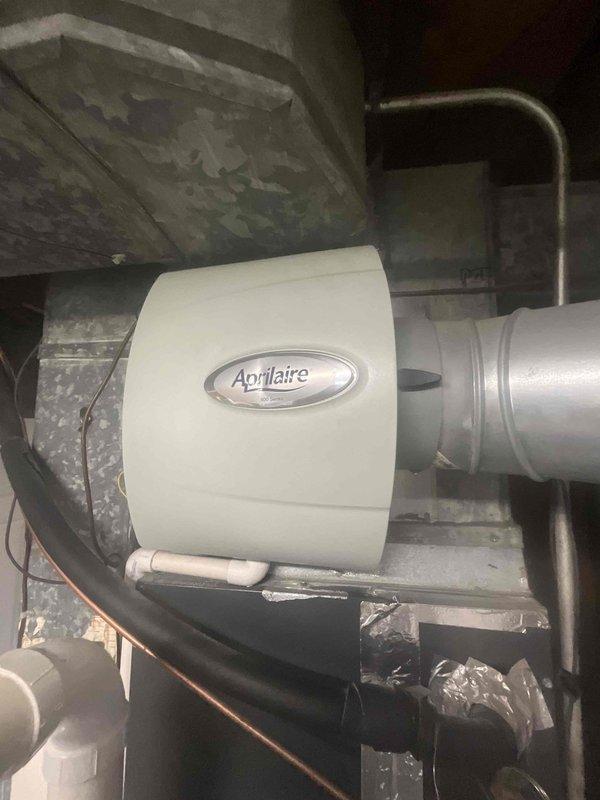 Completed comprehensive air conditioning tune-up and system inspection. Performed standard maintenance protocol including checking refrigerant levels, cleaning condenser coils, inspecting electrical connections, and testing thermostat operation. Documented system components including Aprilaire humidifier integration with ductwork and noted exterior unit condition with visible wear on flexible duct material and minor deterioration requiring future monitoring.