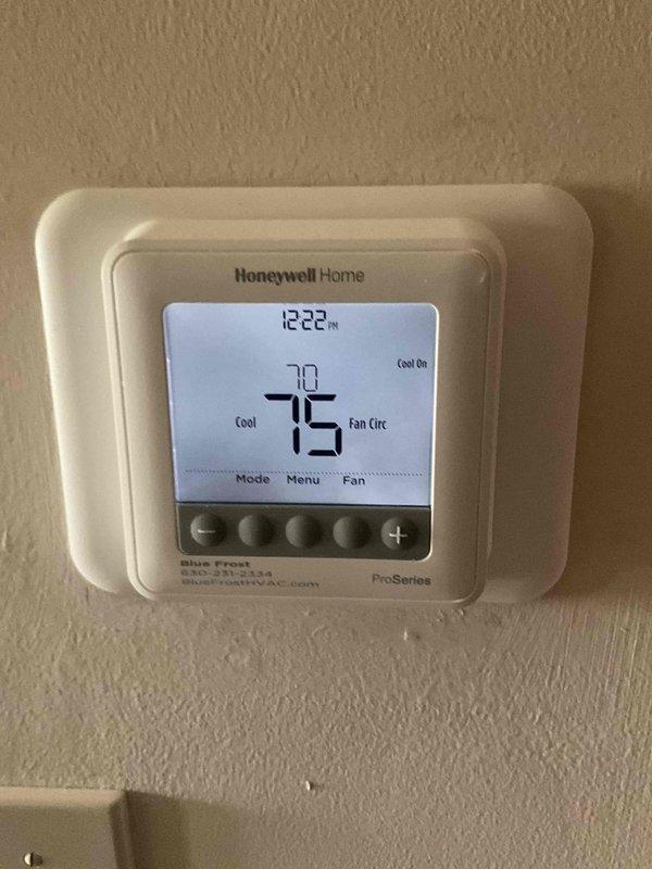 Completed comprehensive BFMA tune-up service on 3-year-old air conditioning system during morning appointment window. Performed standard AC maintenance protocol including inspection of condenser unit, which revealed significant dirt and debris accumulation on coil fins with heavy soiling on one side requiring attention. Verified thermostat operation showing Honeywell Home ProSeries unit functioning properly in cooling mode with system maintaining 75°F setpoint and circulating fan operational.