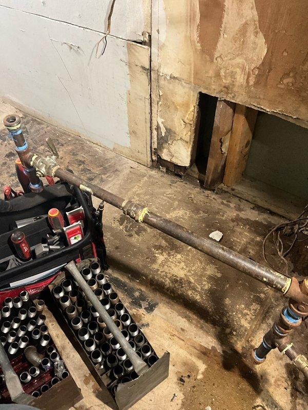 Completed residential water heater elevation and flue adjustment in basement utility area. Installed concrete blocks beneath existing tank to raise unit to proper height per code requirements. Adjusted and repositioned flue piping to ensure proper venting alignment and clearances following elevation of water heater. Verified all plumbing connections, gas lines, and safety controls remained properly secured and operational after repositioning work was completed.