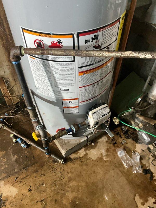 Completed residential water heater elevation and flue adjustment in basement utility area. Installed concrete blocks beneath existing tank to raise unit to proper height per code requirements. Adjusted and repositioned flue piping to ensure proper venting alignment and clearances following elevation of water heater. Verified all plumbing connections, gas lines, and safety controls remained properly secured and operational after repositioning work was completed.