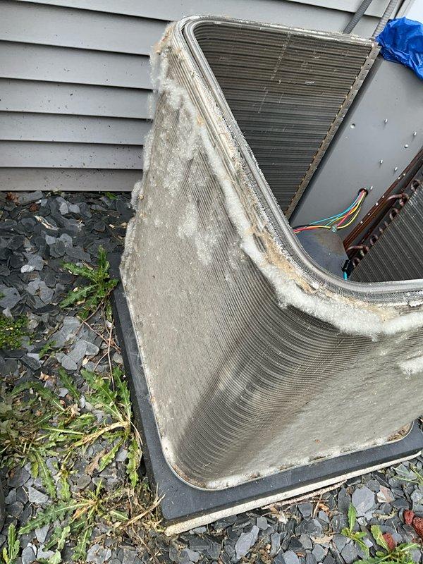 Completed spring maintenance tune-up on residential air conditioning system. Performed comprehensive inspection of outdoor condenser unit, which showed signs of age with visible dirt accumulation, debris buildup on coil fins, and whitish residue on metal surfaces. Cleaned condenser coils to remove environmental debris, dust, and lint accumulation from fin surfaces and front panel. Inspected refrigerant lines and electrical connections for proper condition. Verified unit operation and system functionality following maintenance procedures.