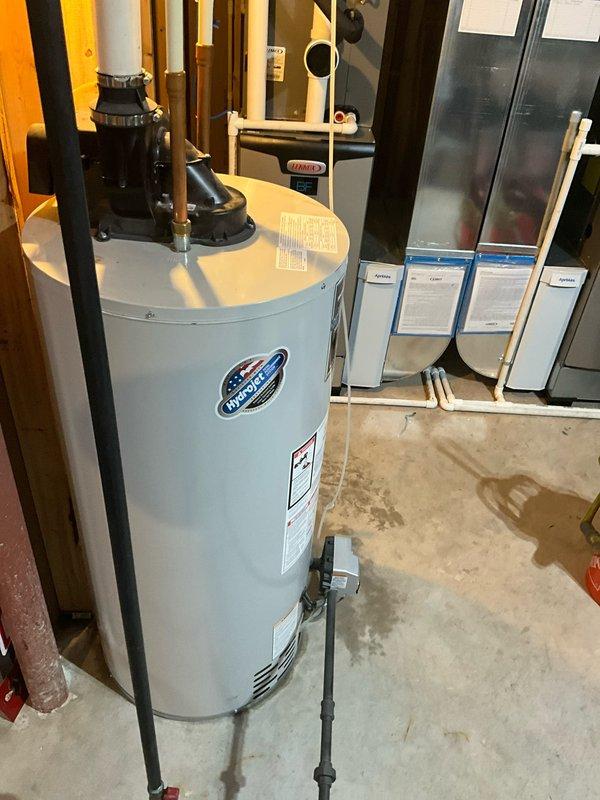 Responded to service call for leaking tanked water heater in residential basement utility room. Upon arrival, inspected 10-year-old water heater unit and identified active leak requiring attention. Assessed all plumbing connections, pressure relief valve, and discharge piping at top of unit. Documented existing conditions including water staining on concrete floor and evaluated overall system integrity. Provided recommendations for repair or replacement based on age of equipment and current condition of unit.