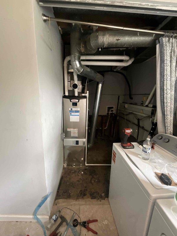Completed full HVAC system installation featuring a Lennox 80% AFUE gas furnace (model EL297UH070XV36BK) paired with a 2-ton air conditioning condenser (model EL15KC1-024) and evaporator coil (model CK40CT-24B). Installed new ductwork connections with insulated supply plenums, configured Ecobee smart thermostat for system control, and integrated AA1210 accessory package for optimal system performance. Coordinated with plumbing contractor to elevate water heater on brick platform and adjust flue piping to accommodate new furnace installation and ensure proper venting clearances in the utility room.